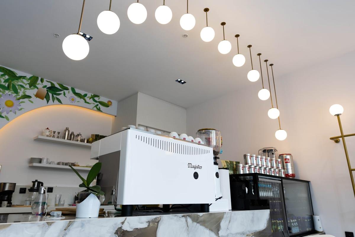 Kafe bölümündeki kahve barı; espresso makinesi ve mermer tezgâh