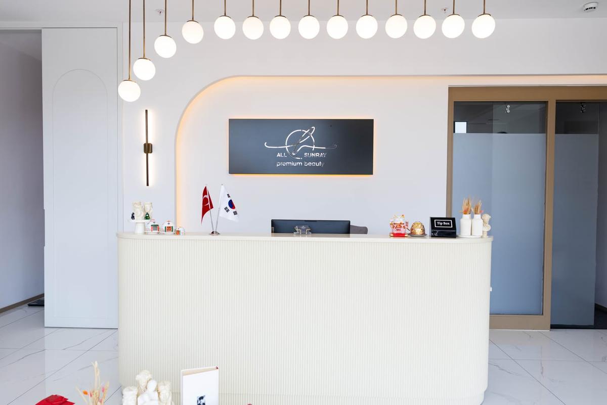 AllSunray resepsiyon bankosu ve arkasındaki aydınlatmalı marka tabelası